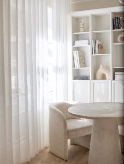 Hvide transparente stofgardiner fra Luxaflex, der bryder sollyset i rummet